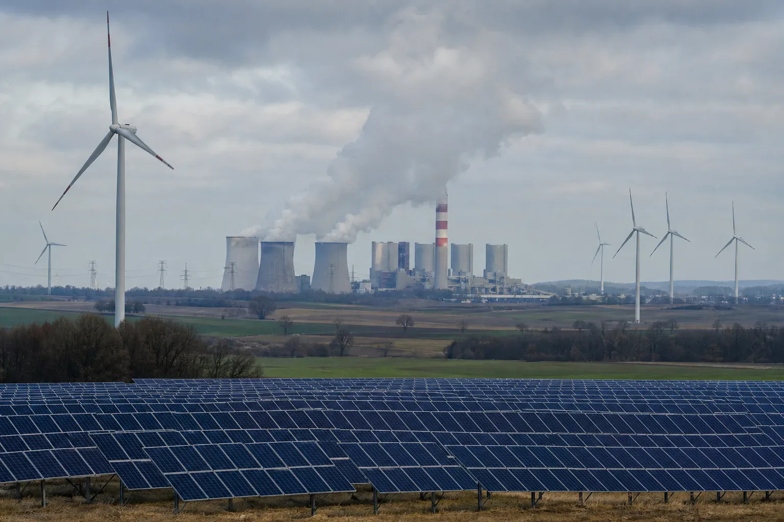 Krajobraz energetyczny z elektrownią węglową, turbinami wiatrowymi i panelami słonecznymi
